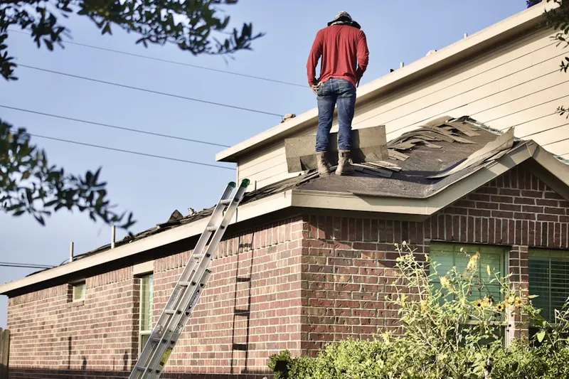 Professional roofer working on a residential roof in Athens